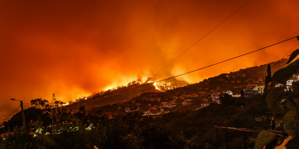 Brush fire burning around a suburb highlighting the need for disaster insurance