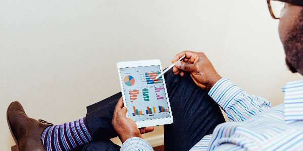 business man reads a tablet, analyzing the options given to him from an insurance broker