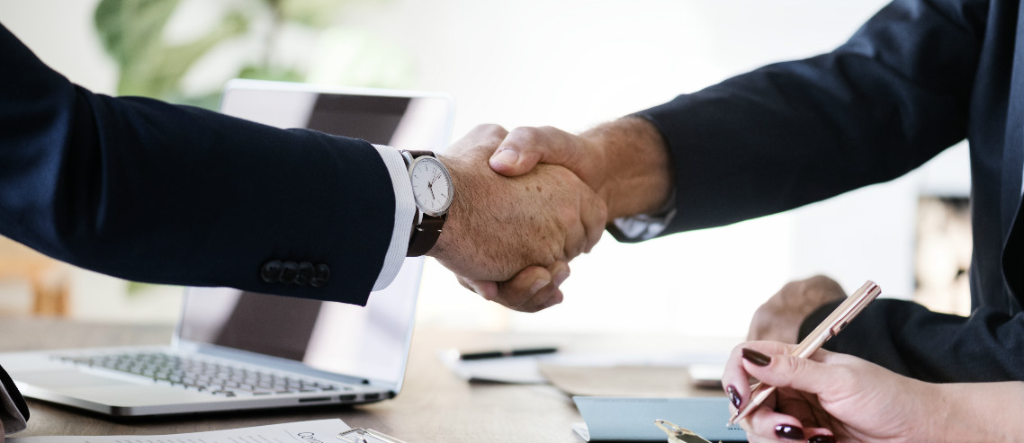 a businessman shakes hands with a benefits consultant