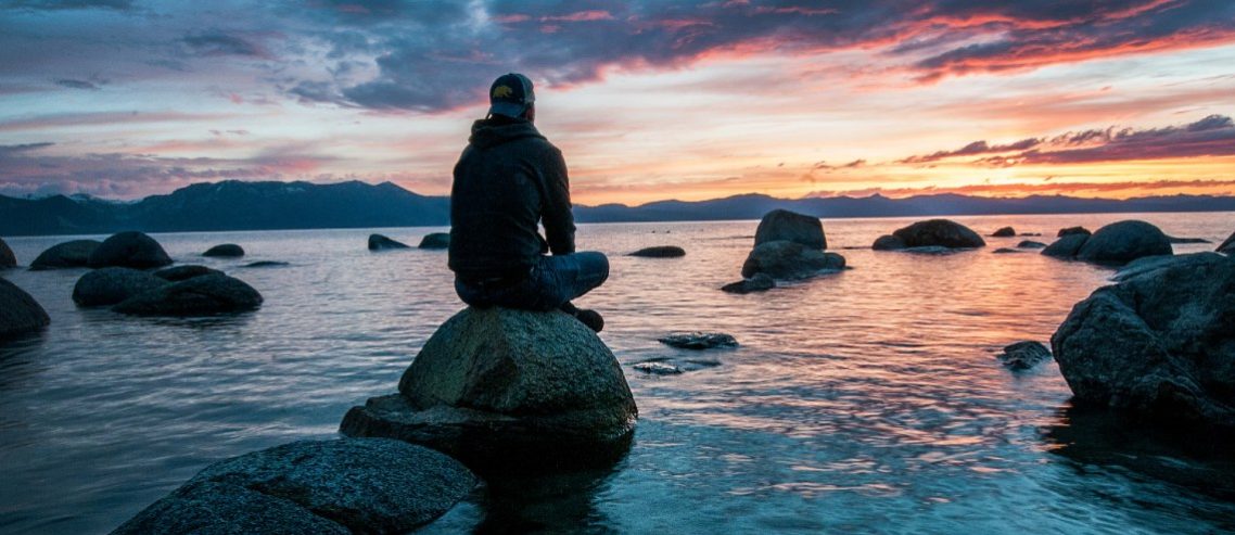 Man meditating at the sea to relieve stress and anxiety