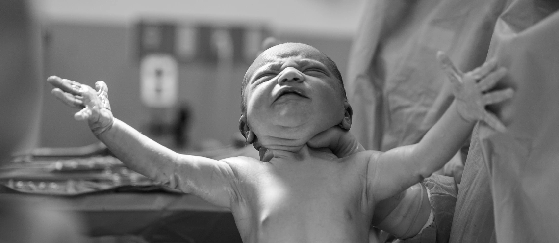 A grayscale image of a newborn baby