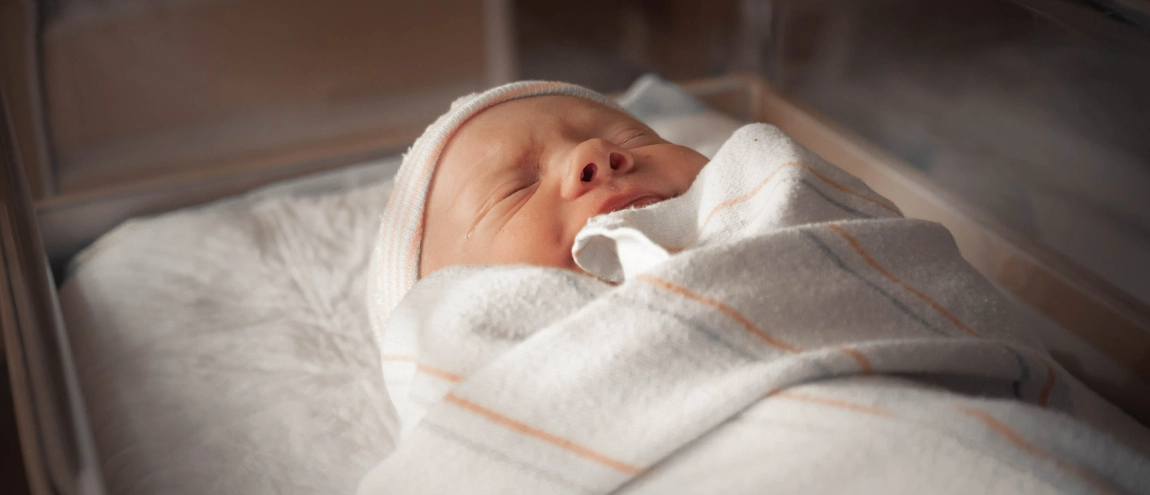 A newborn sleeping on a hospital's bed