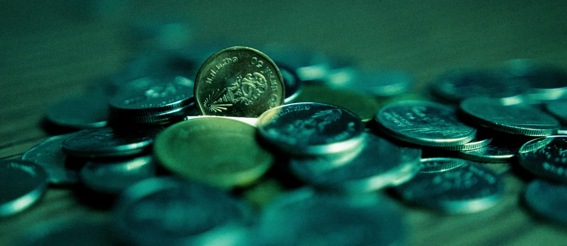 1-baht and 50-satang coins laying on a table in a dark room