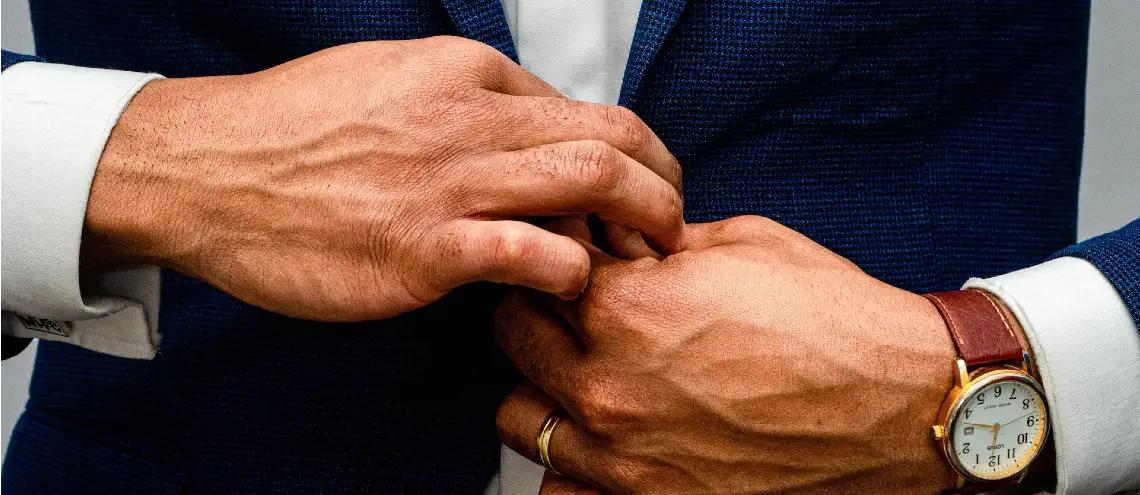 Man's hands buttoning up suit jacket