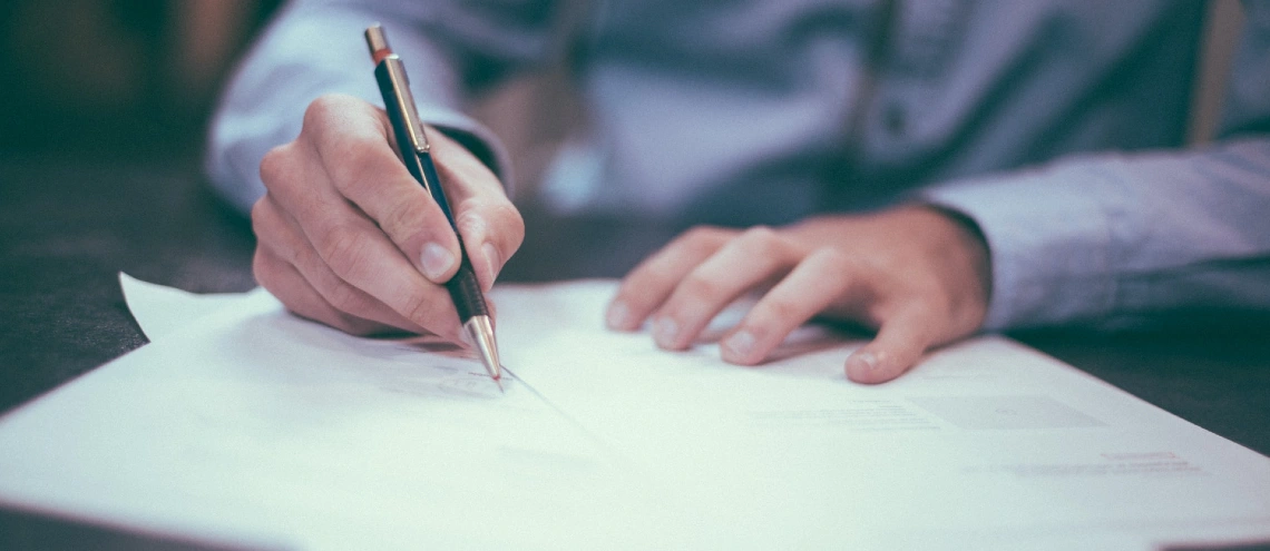 Person holding a pen signing a contract 