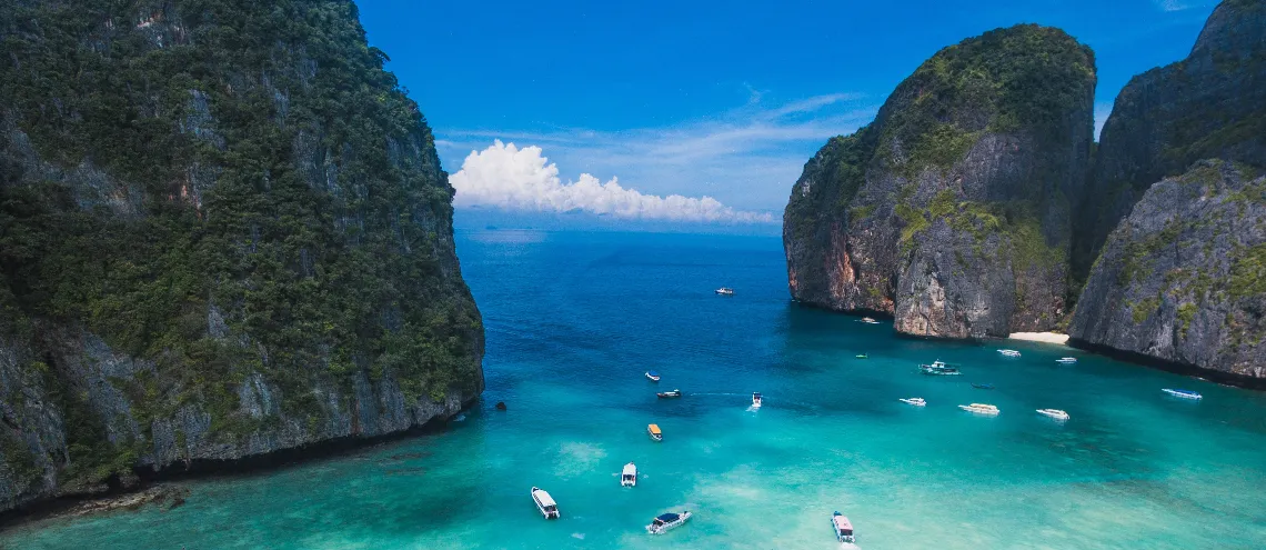 A crystal clear sea on a pristine shore overlooking a bright blue sky