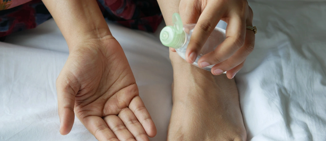 A woman using bug repellent lotion on her skin