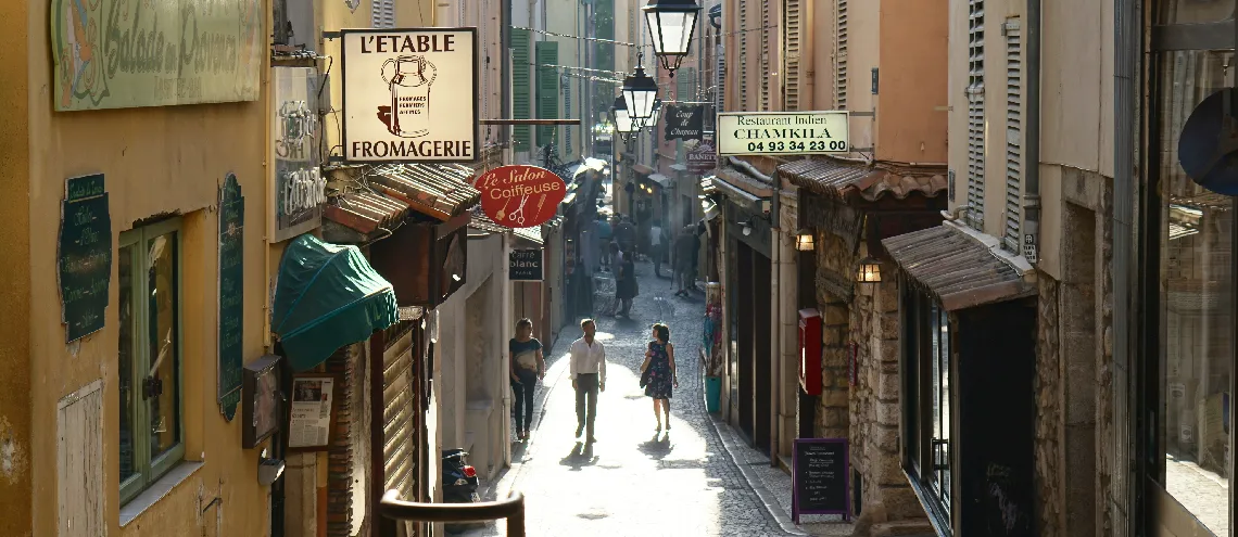 People walking in a French street with shops
