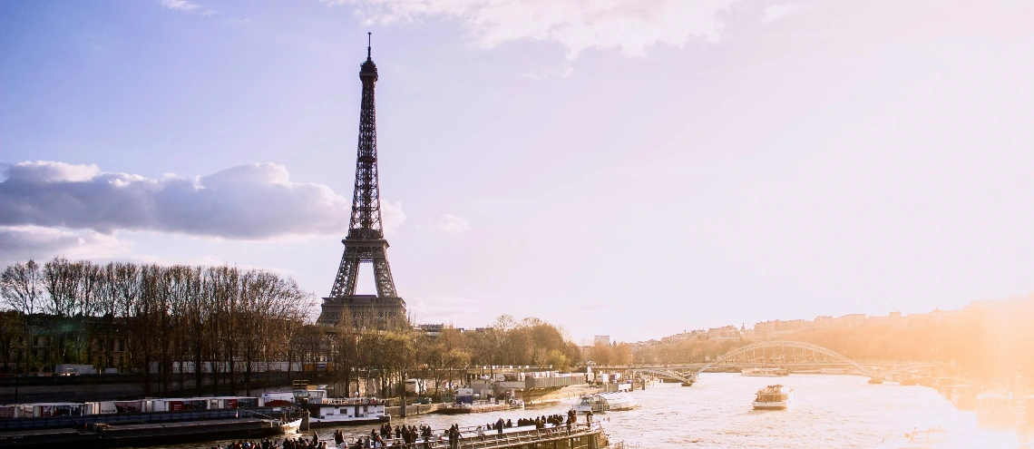 The Eiffel Tower along a river full of boats